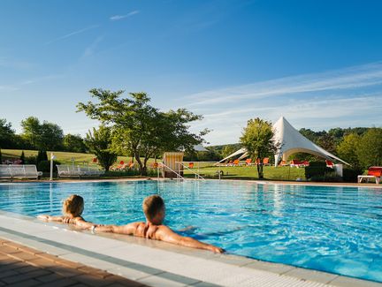 Paar im Außenbecken der ThermeNatur Bad Rodach im Sommer